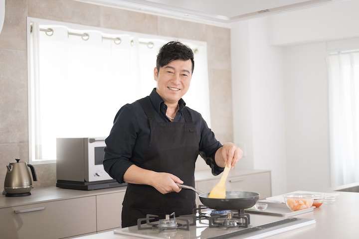 キッチンで調理する黒沢薫さん