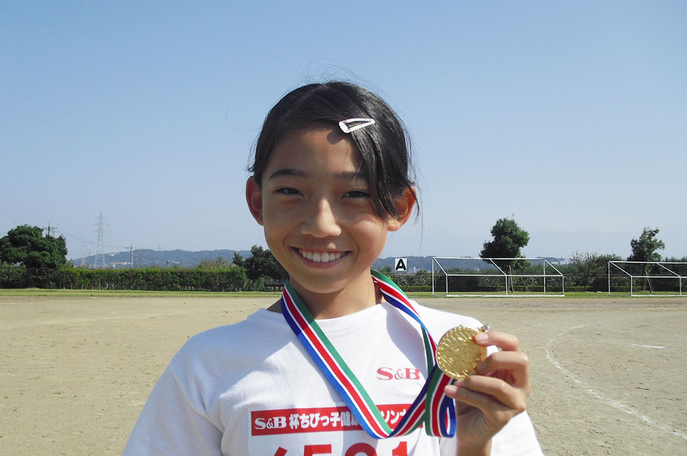 6年女子優勝の大塚さん、金メダルを片手ににっこり。
